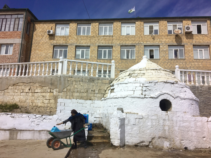 Эта женщина наполняет водой кувшины из общественного крана ниже главного административного здания Уркараха. Фото: Макензи Холланд