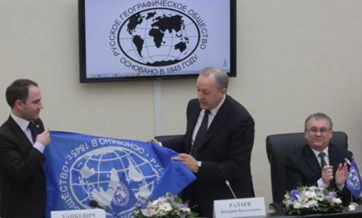 Директор Департамента регионального развития Александр Хацкевич вручает флаг РГО губернатору региона Валерию Радаеву