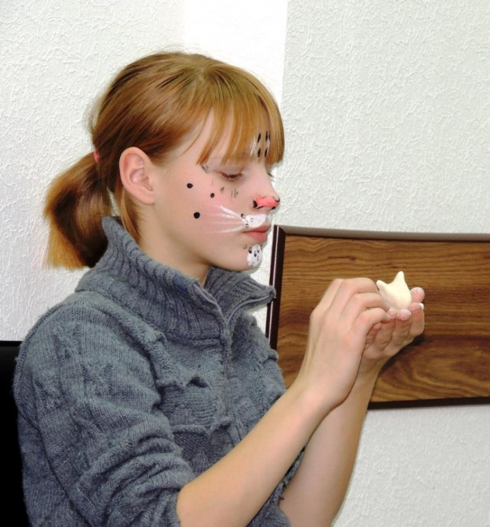 Участница праздничной программы лепит ирбиса из солёного теста