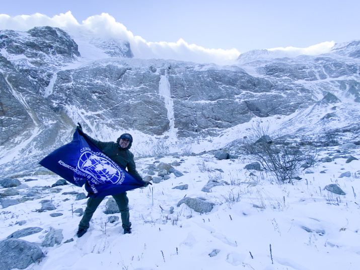 Андрей Прокудин с флагом Центра воздухоплавания Белая скала РГО у ледника Тана. Фото Паленко Ирина
