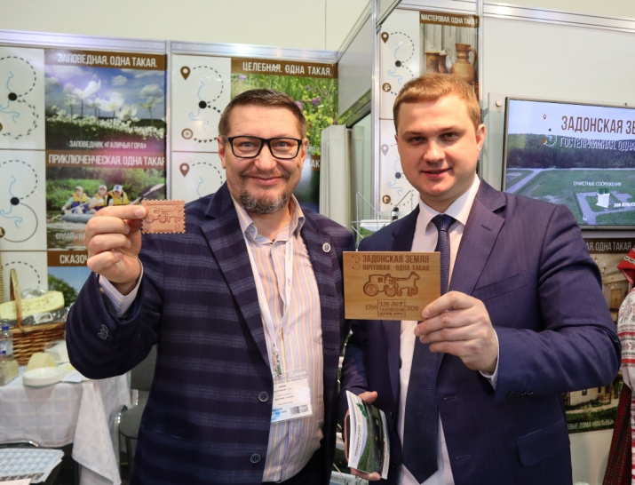 Валерий Сушков с главой администрации Задонского муниципального района Липецкой области Алексеем Щедровым презентуют первые в мире 3D деревянные марку и почтовую карточку «Задонская земля» на Международной туристической выставке «ИНТУРМАРКЕТ-2021»