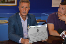 Михаил Малахов демонстрирует памятную табличку, которую планируется установить на горе Юнона