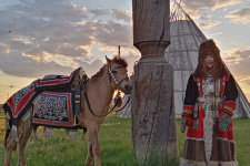 Девушка в традиционной якутской одежде и лошадь в праздничном убранстве возле коновязи сэргэ. Фото предоставлено оргкомитетом фестиваля