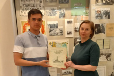 Артемий Горбунов передает атлас музею Державинского университета; фото: Артемий Горбунов