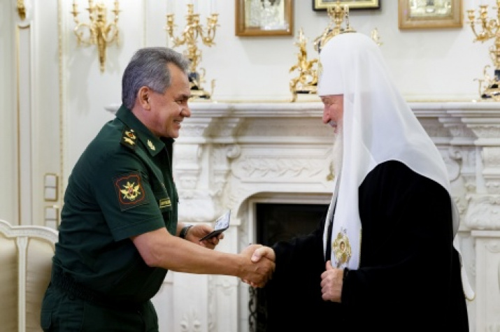 The President of the Russian Geographical Society Sergey Shoygu is giving a membership card of the Society to the Patriarch Kirill  